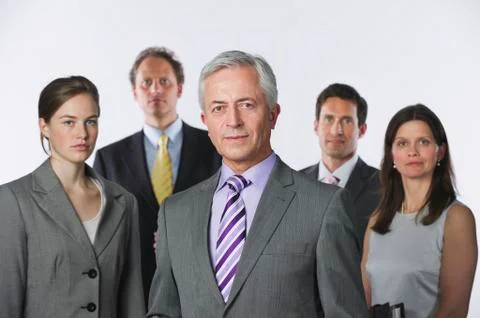 Business people against white background, smiling, portrait Stock Photos