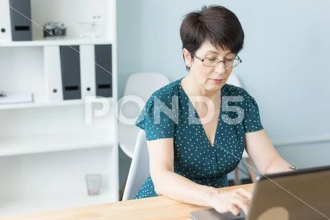 Business people and technology concept - Middle aged business woman working on Stock Photos