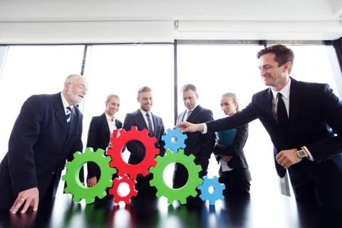 Business people assembling cogwheels Stock Photos