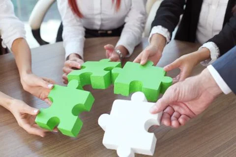 Business people assembling puzzle Stock Photos