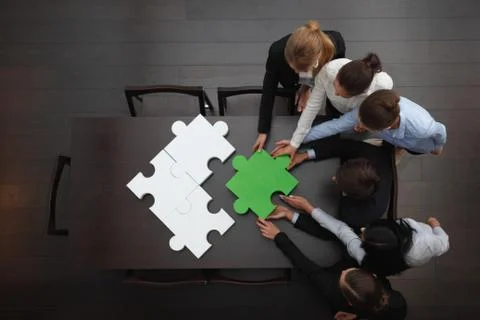 Business people assembling puzzle Stock Photos