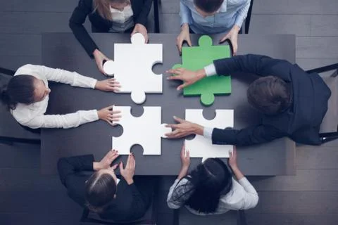 Business people assembling puzzle Stock Photos
