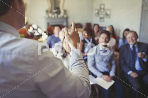 Business people in audience watching businessman leading business conference Stock Photos
