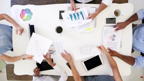 Business people at a desk passing documents, overhead shot Stock Footage 78939210
