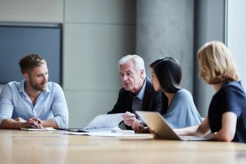 Business people discussing paperwork in conference room Stock Photos