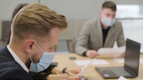 Business people having a meeting, working in the office, wearing medical mask. Stock Footage
