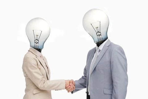 Business people with lightbulb heads greeting with a handshake Stock Photos