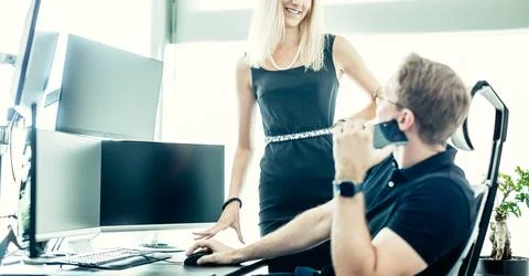 Business people looking at data on multiple computer screens, solving business Stock Photos