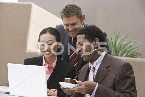 Business People Looking At Laptop During Their Coffee Break Stock Photos