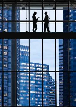 Business people meeting on an elevated walkway between office buildings. Stock Photos
