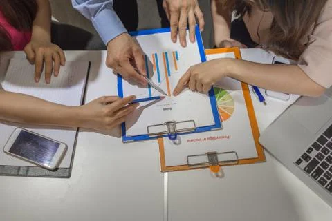 Business people point at the chart at the same time Stock Photos