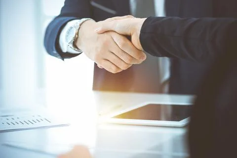 Business people shaking hands finishing up meeting or negotiation in sunny Stock Photos
