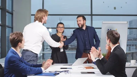 Business people shaking hands at interview while others clap at the office. Stock Footage 82653560
