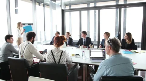 Business people sitting at table while female colleague giving presentation Stock Footage 59544620