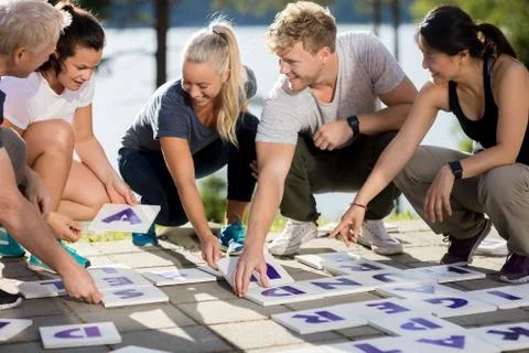Business People Smiling While Solving Crossword On Patio Foto stock