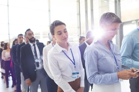 Business people standing in queue in lobby Stock Photos