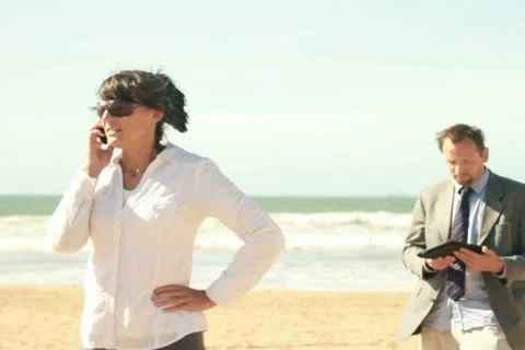 Business people with tablet computer and cellphone on the beach Stockbeeldmateriaal 10851260
