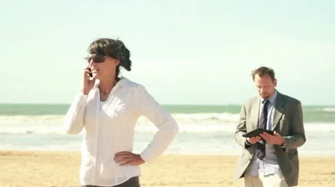 Business people with tablet computer and cellphone on the beach Stockbeeldmateriaal 10851271