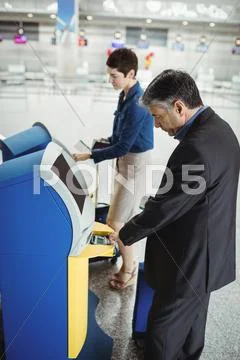 Business People Using Self Service Check-In Machine