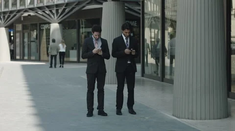 Business people using smartphone computer near office: team work, mobile phones Stock Footage 42992170