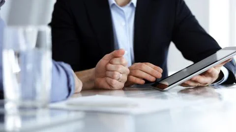 Business people using tablet computer while working together at the desk in Stock Photos
