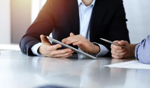 Business people using tablet computer while working together in sunny modern Stock Photos