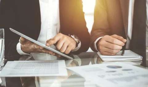 Business people using tablet computer while working together in sunny office Stock Photos