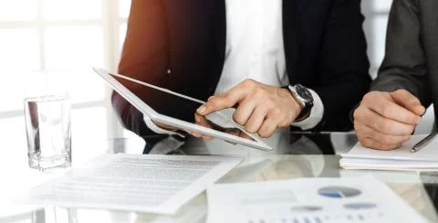 Business people using tablet computer while working together in sunny office Stock Photos
