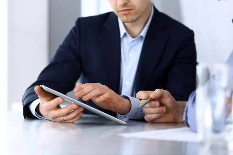 Business people using tablet computer while working together at the desk in Stock Photos