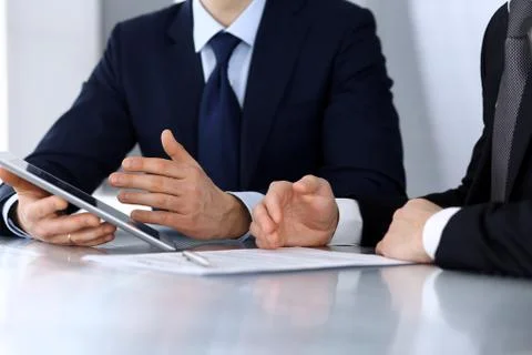 Business people using tablet computer while working together at the desk in Stock Photos