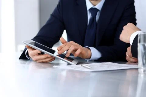 Business people using tablet computer while working together at the desk in Stock Photos
