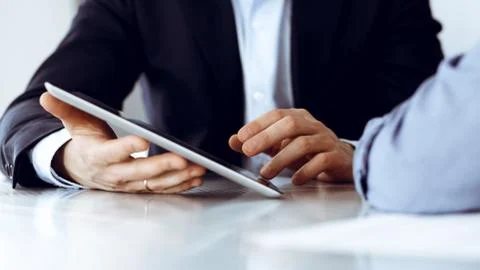 Business people using tablet computer while working together at the desk in Stock Photos