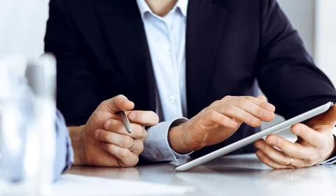 Business people using tablet computer while working together at the desk in Stock Photos