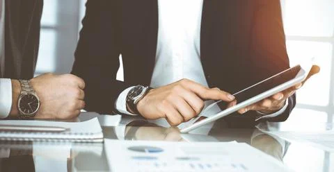 Business people using tablet computer while working together in sunny office Stock Photos