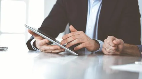 Business people using tablet computer while working together at the desk in Stock Photos