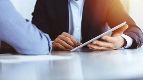 Business people using tablet computer while working together in sunny modern Stock Photos