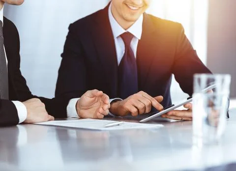Business people using tablet computer while working together in sunny modern Stock Photos