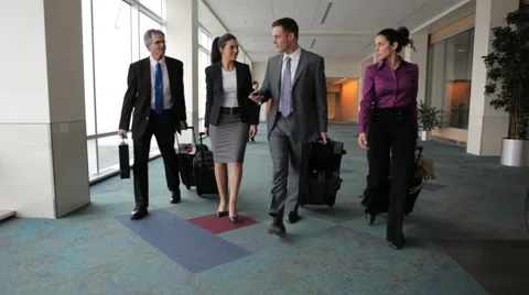 Business people walk through airport lobby Stock Footage