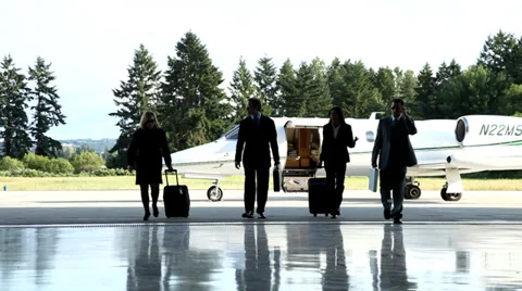 Business people walking away from jet Stock Footage 32710702