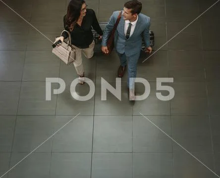 Business people walking through a hallway with luggage Stock Photos