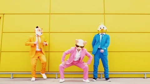 Business people wearing animal masks dancing in front of yellow wall Stock Footage 155624800