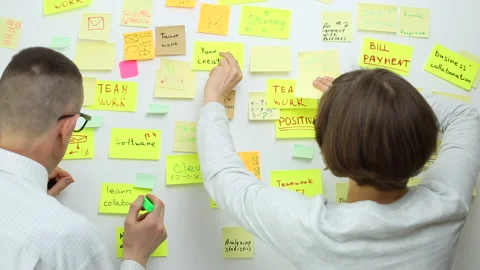 Business people write down an important note, using on the paper stickers post.  Video stock 131091640