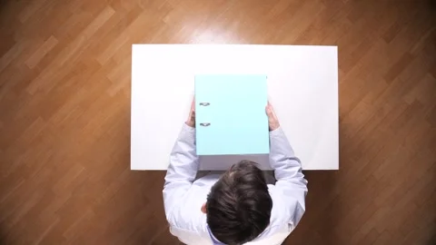 Business person holding a large stack of colorful binders and files, organizing Stock Footage 326939898