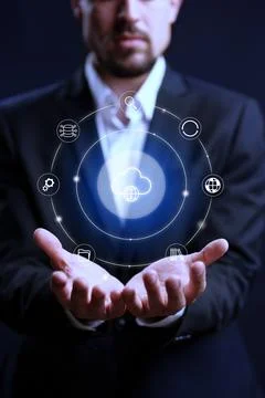 Business person holds cloud computing symbols in hands at night Fotos Stock