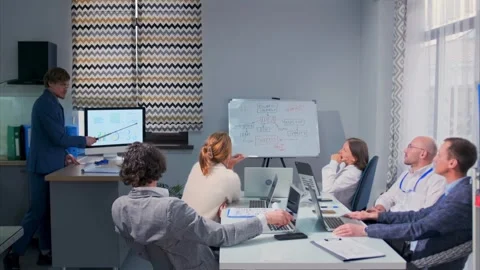 Business presentation with diverse team analyzing marketing strategy charts in Stock Footage 315941180