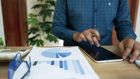 Business Professional Analyzing Data on Tablet, Person using a tablet at a .. Stock Footage 318056918