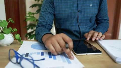 Business Professional Analyzing Data on Tablet, Person using a tablet at a .. Stock Footage 318056926