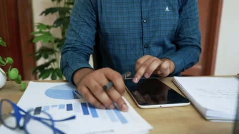 Business Professional Analyzing Data on Tablet, Person using a tablet at a .. Stock Footage 318056931