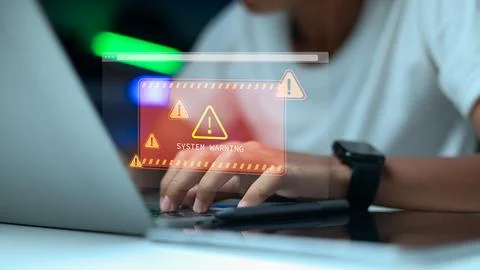 Business professional facing system warning and cyber attack on laptop 스톡 사진