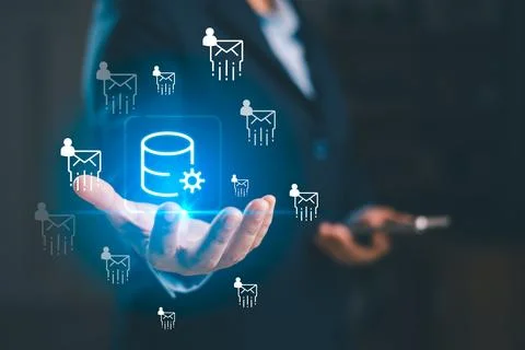 A business professional presenting glowing database icon with email user sy.. Foto stock